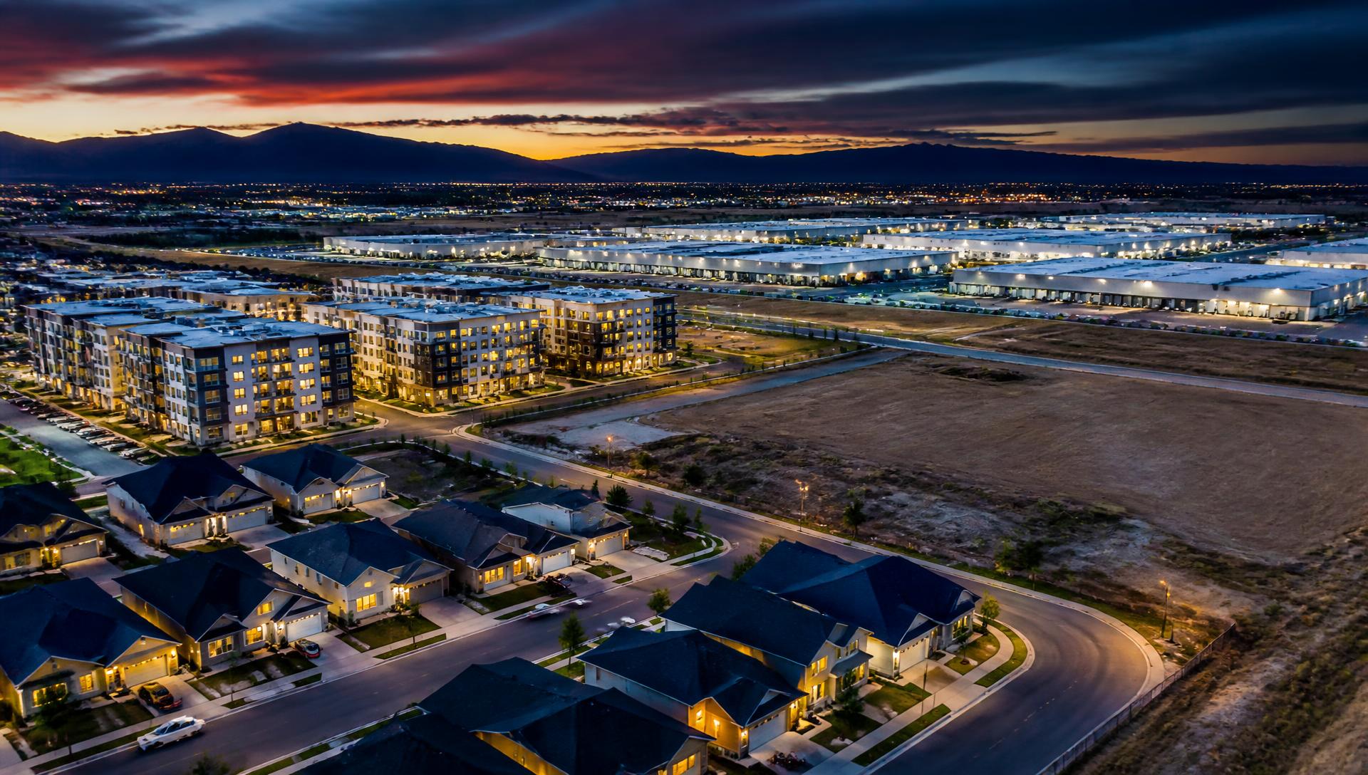 Aerial view of American single-family homes, apartment buildings, warehouses, and development land at dusk